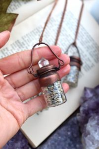 lavender necklace in a bottle with a clear quartz point